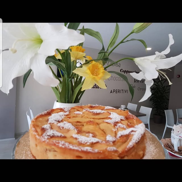 Interno di Trés Bon con torta di mele e fiori freschi